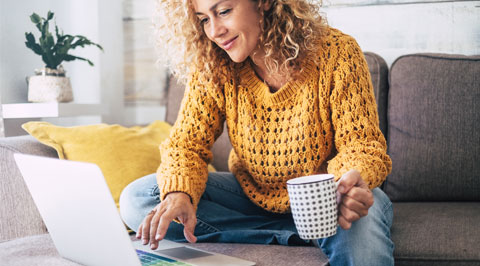 Frau auf Couch mit Laptop