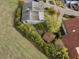Luftaufnahme eines verwitterten Hauses im Grünen