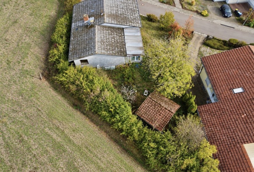 Luftaufnahme eines verwitterten Hauses im Grünen