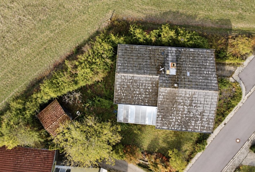 Drohnenansicht eines überwucherten Landhauses