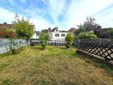 Komplett eingezäunter Garten mit saftig grüner Wiese und Str